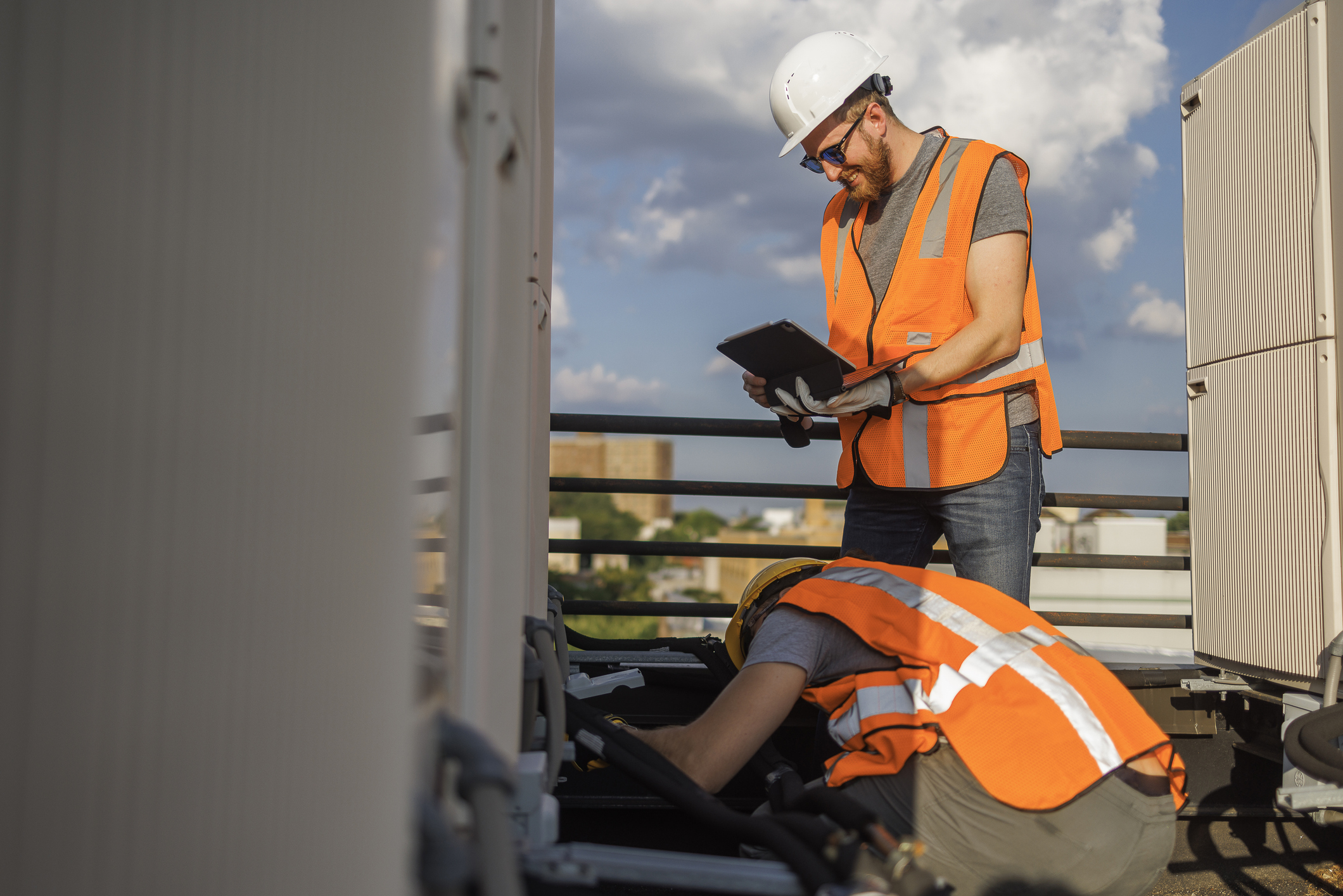 safety inspectors, high res vests, hard hats, tablet in hand